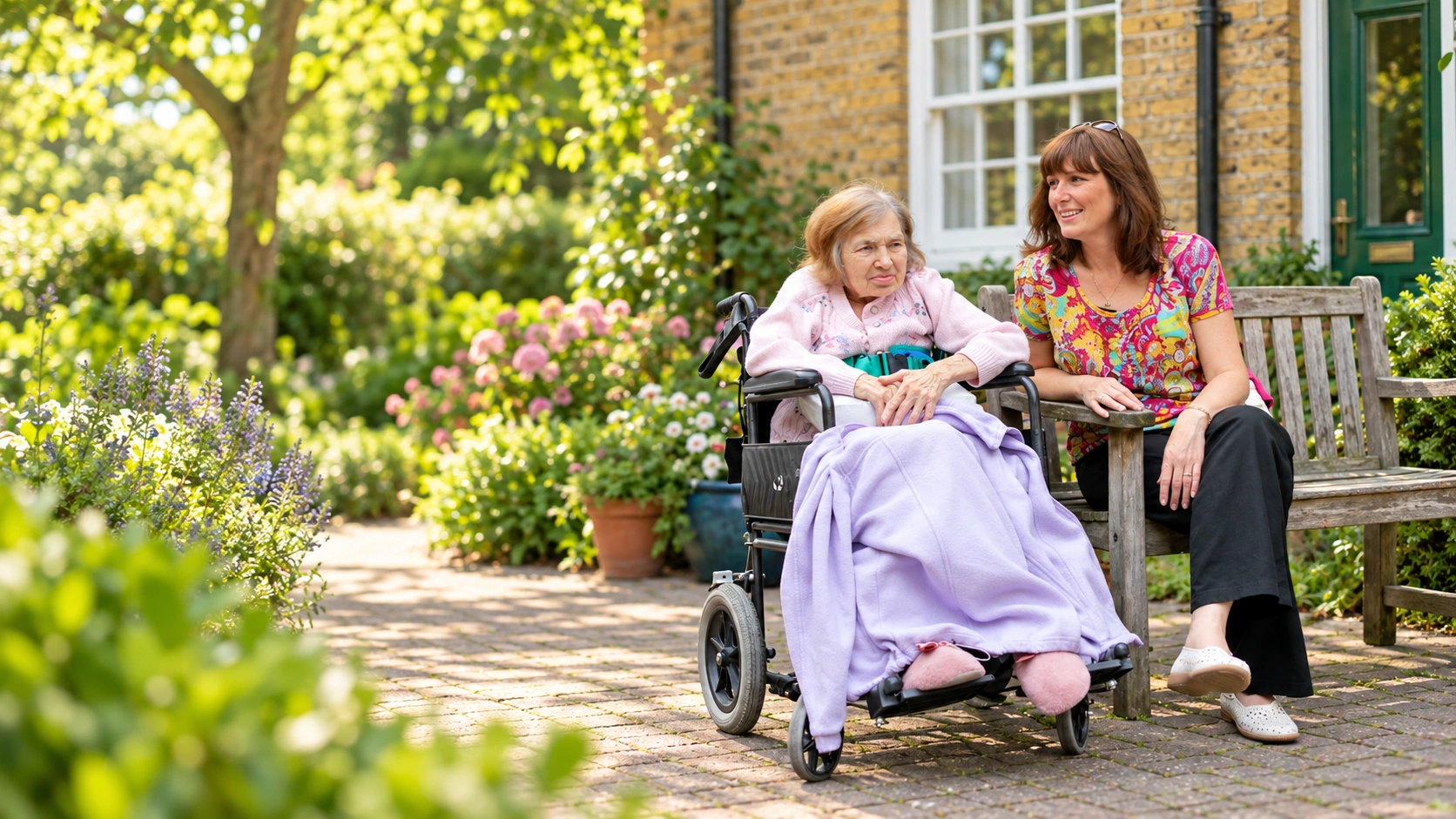 An older woman in a wheelchair enjoying time outdoors with a companion